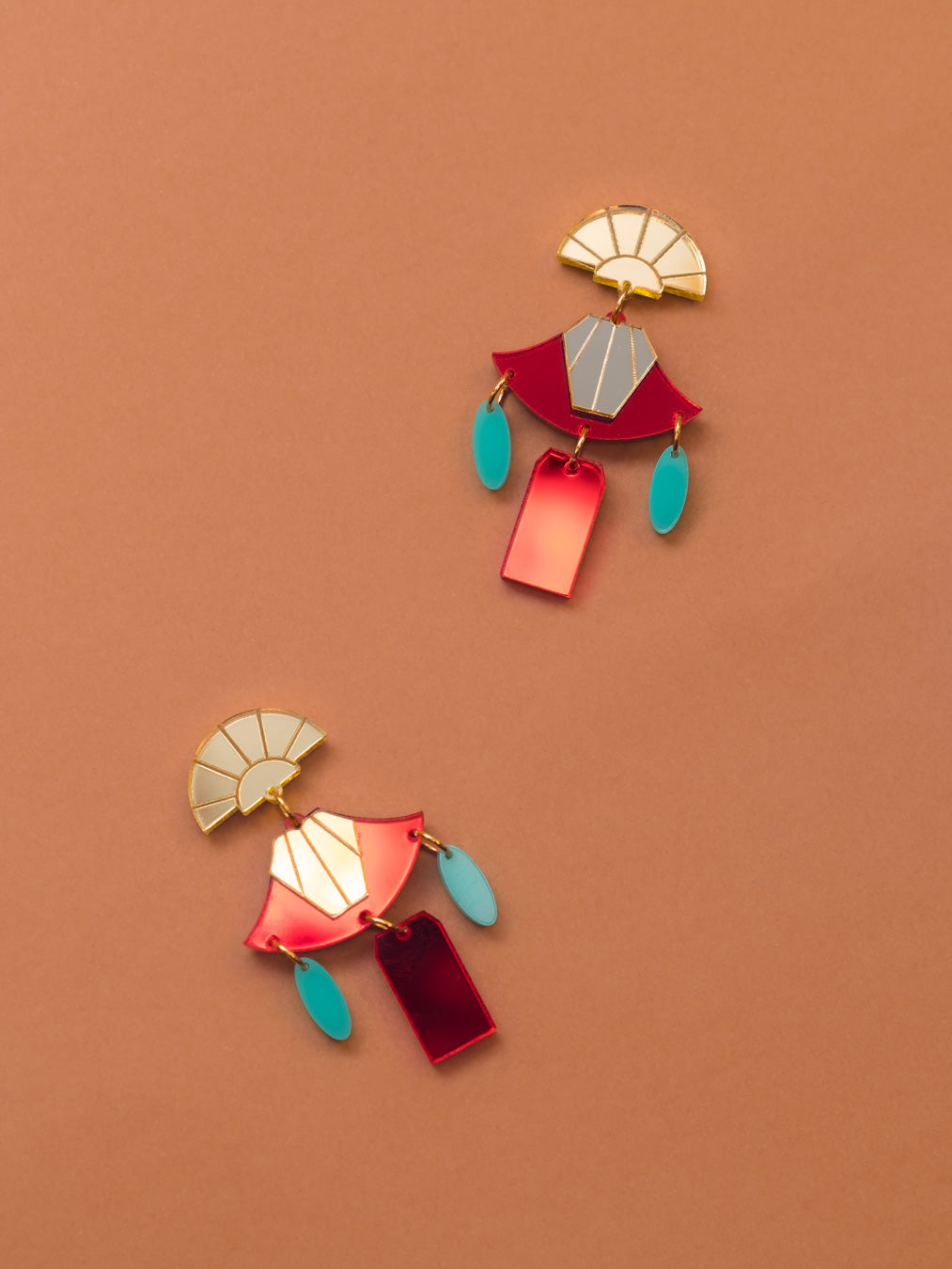 Pendientes de metacrilato rojo y dorado espejo junto con los detalles azul turquesa para hacer de estos pendientes una joya. Inspirados en la pelicula el emperador y sus locuras