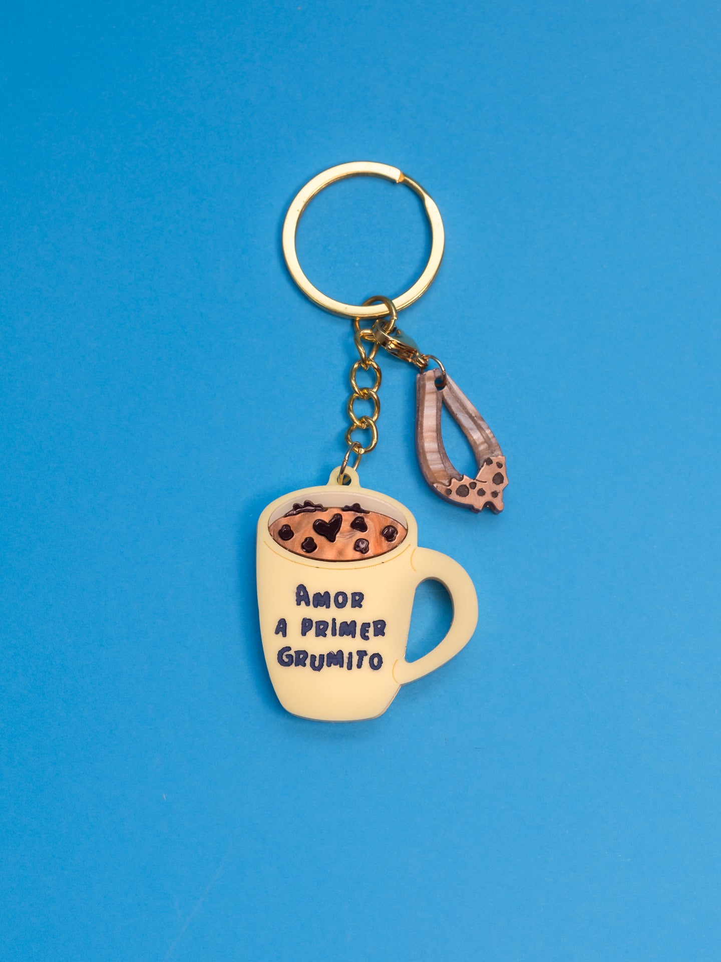 Llavero de The90sisters x ColaCao, hecho en metacrilato, representa una taza de colacao en amarillo y con la frase amor a primer grumito. Producto oficial