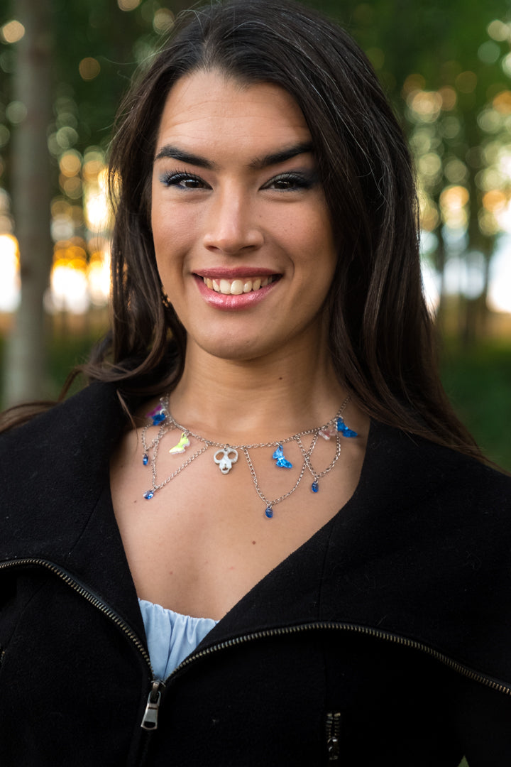 Collar de metacrilato y acero inox. inspirado en las películas de Tim Burton, mariposas espejo, azul e iridiscente culminadas con cristales gota azul y la cabeza de Scraps en el centro para dar ese aspecto elegante y spooky