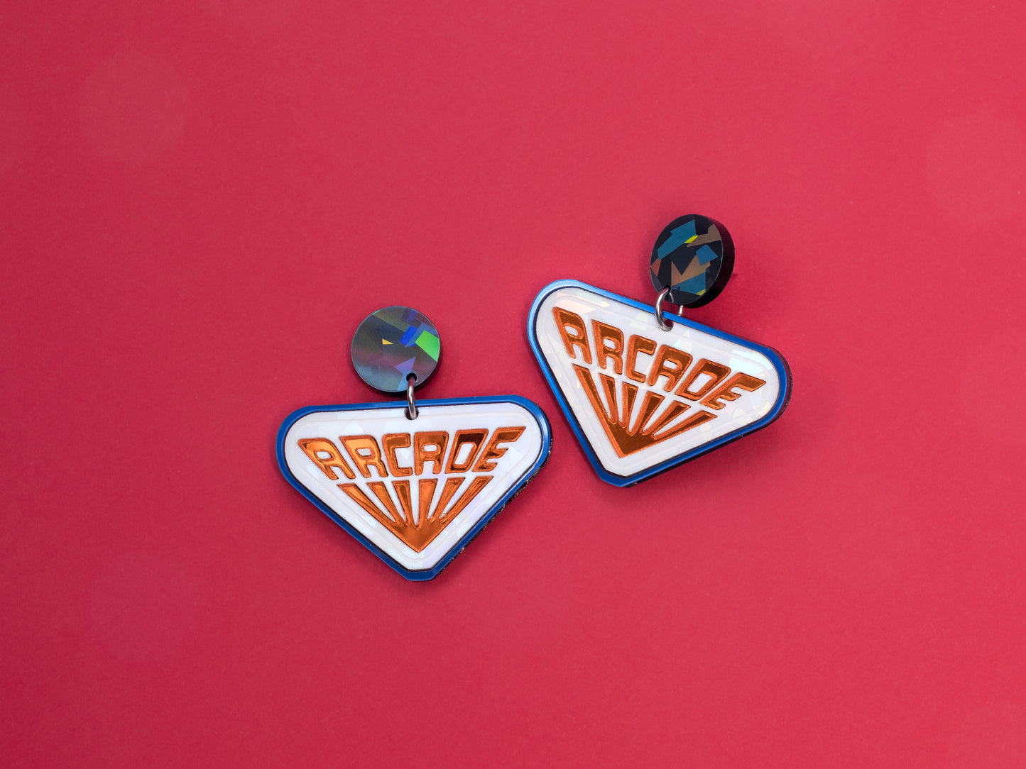 Pendientes de botón inspirados en las recreativas de Stranger Things, hechos con metacrilato de efecto prisma y espejo naranja.