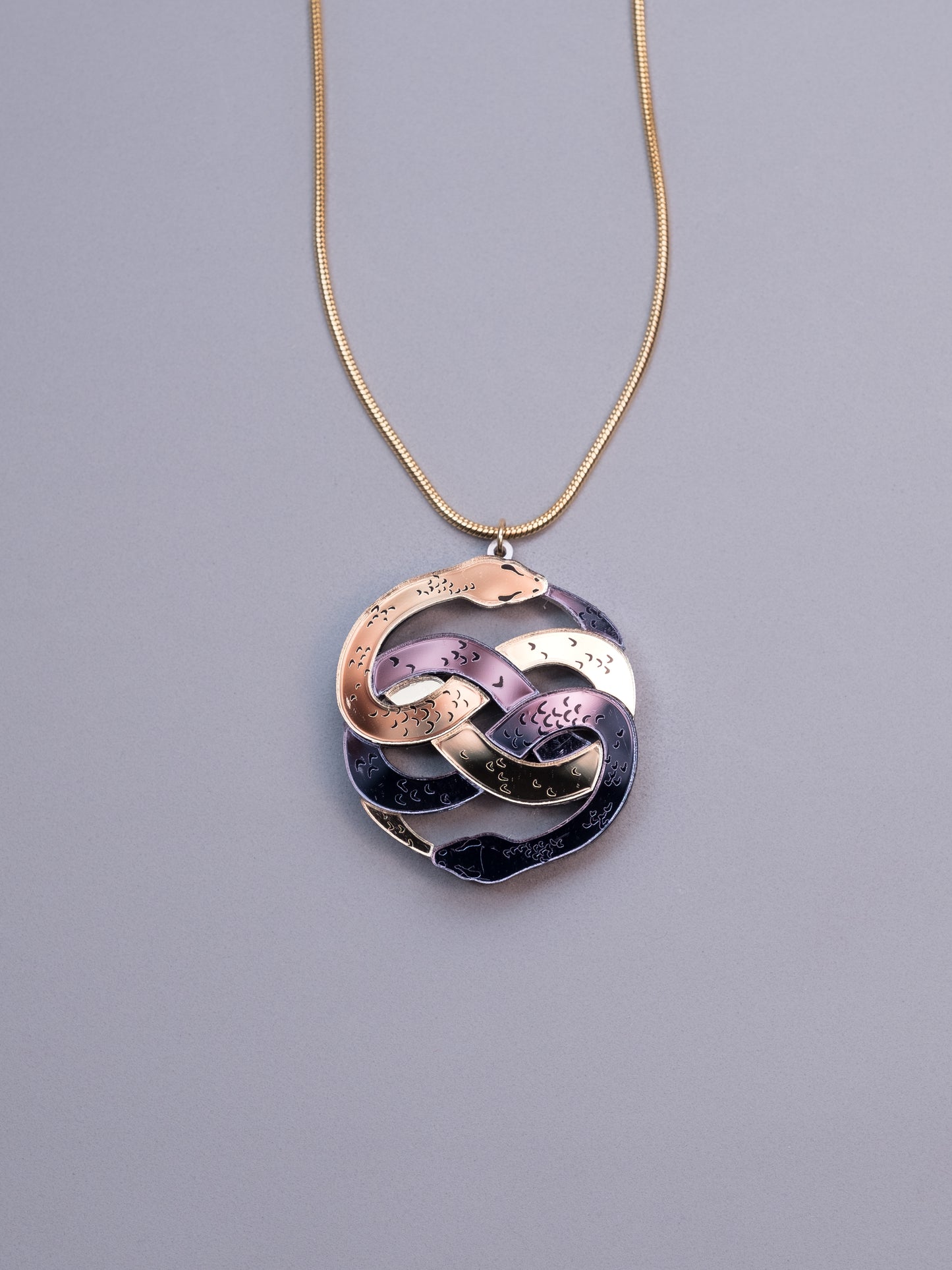 Collar de metacrilato inspirado en la historia interminable. Hecho a mano con metacrilatos espejo dorado y antracita. Con cadena cola de ratón en dorado