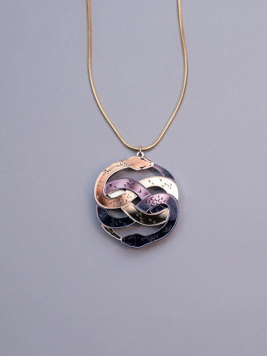 Collar de metacrilato inspirado en la historia interminable. Hecho a mano con metacrilatos espejo dorado y antracita. Con cadena cola de ratón en dorado