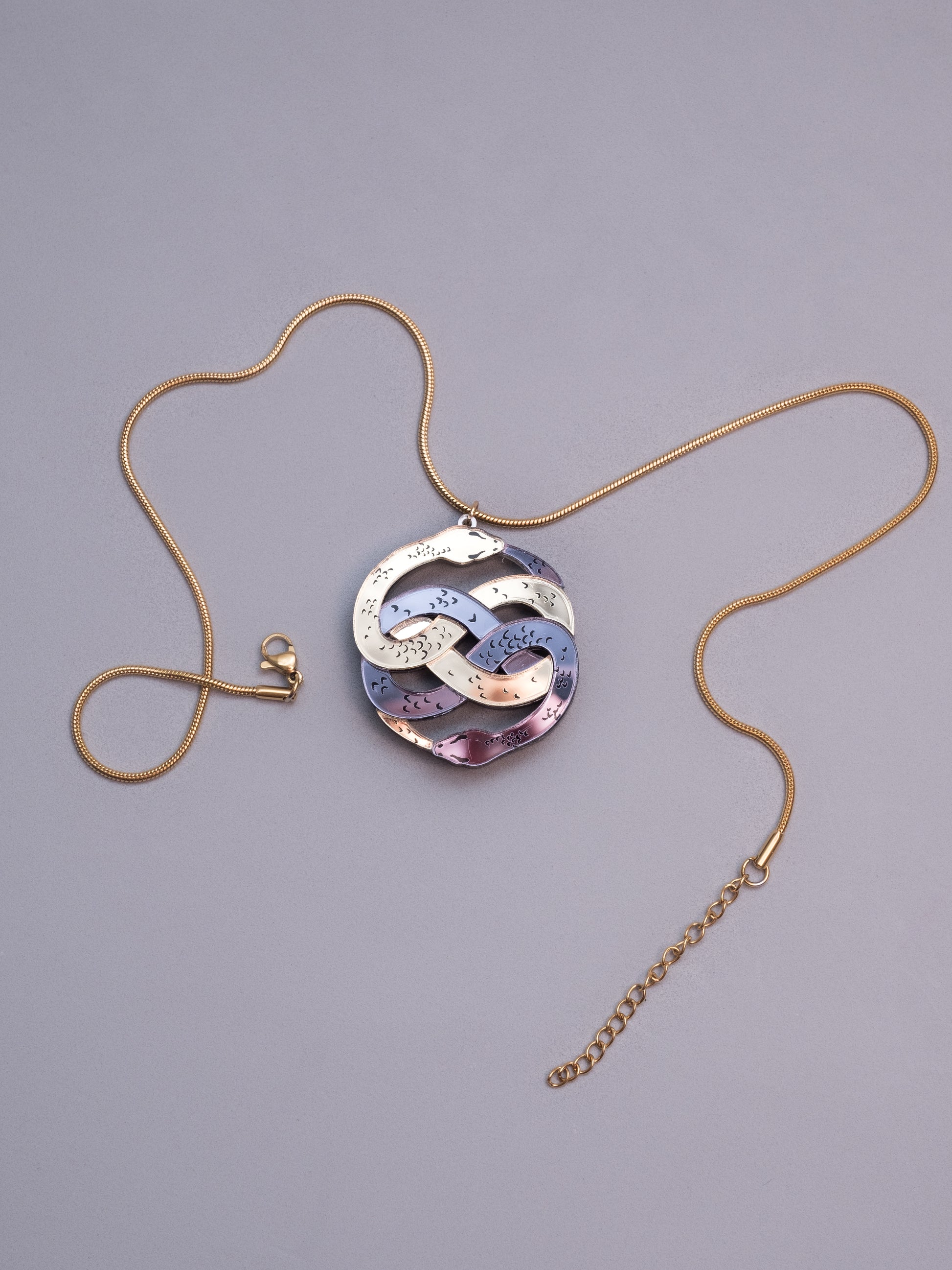 Collar de metacrilato inspirado en la historia interminable. Hecho a mano con metacrilatos espejo dorado y antracita. Con cadena cola de ratón en dorado