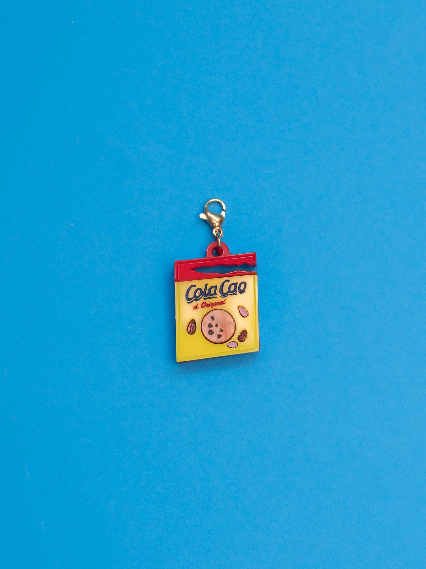 Charms de The90sisters x ColaCao, hechos en metacrilato, en este caso el Sobre de ColaCao,. Producto oficial