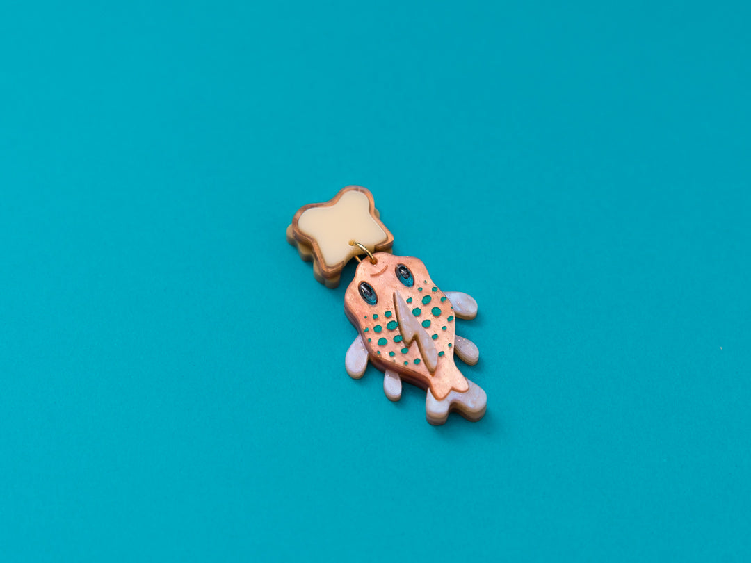 Pendientes de metacrilato naranja nacarado con purpurina y naranja claro dandole color al pez "Gordito" junto con metacrilato crema y marron para el sandwich inspirados en la pelicula de Lilo y Stitch.