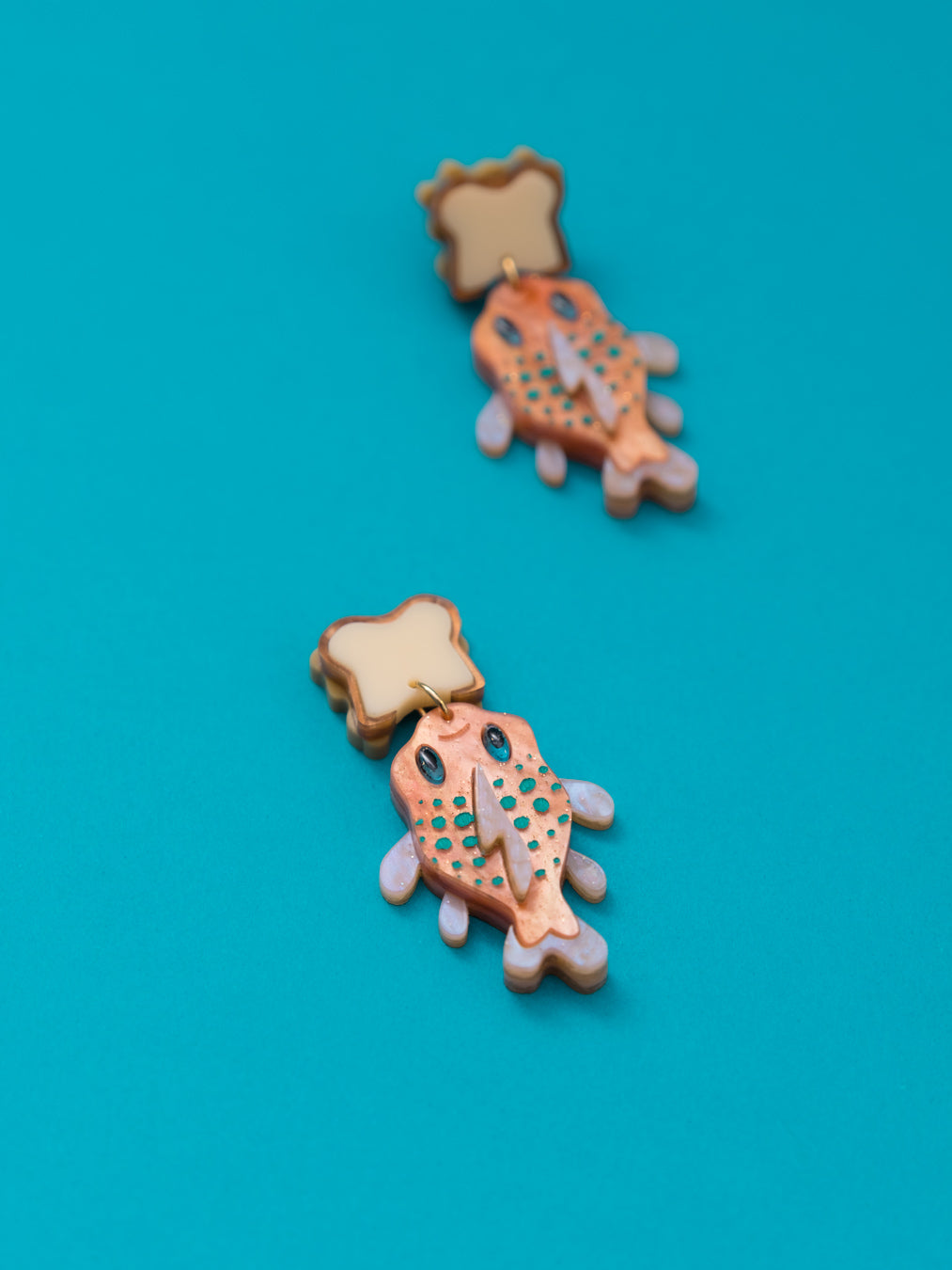 Pendientes de metacrilato naranja nacarado con purpurina y naranja claro dandole color al pez "Gordito" junto con metacrilato crema y marron para el sandwich inspirados en la pelicula de Lilo y Stitch.