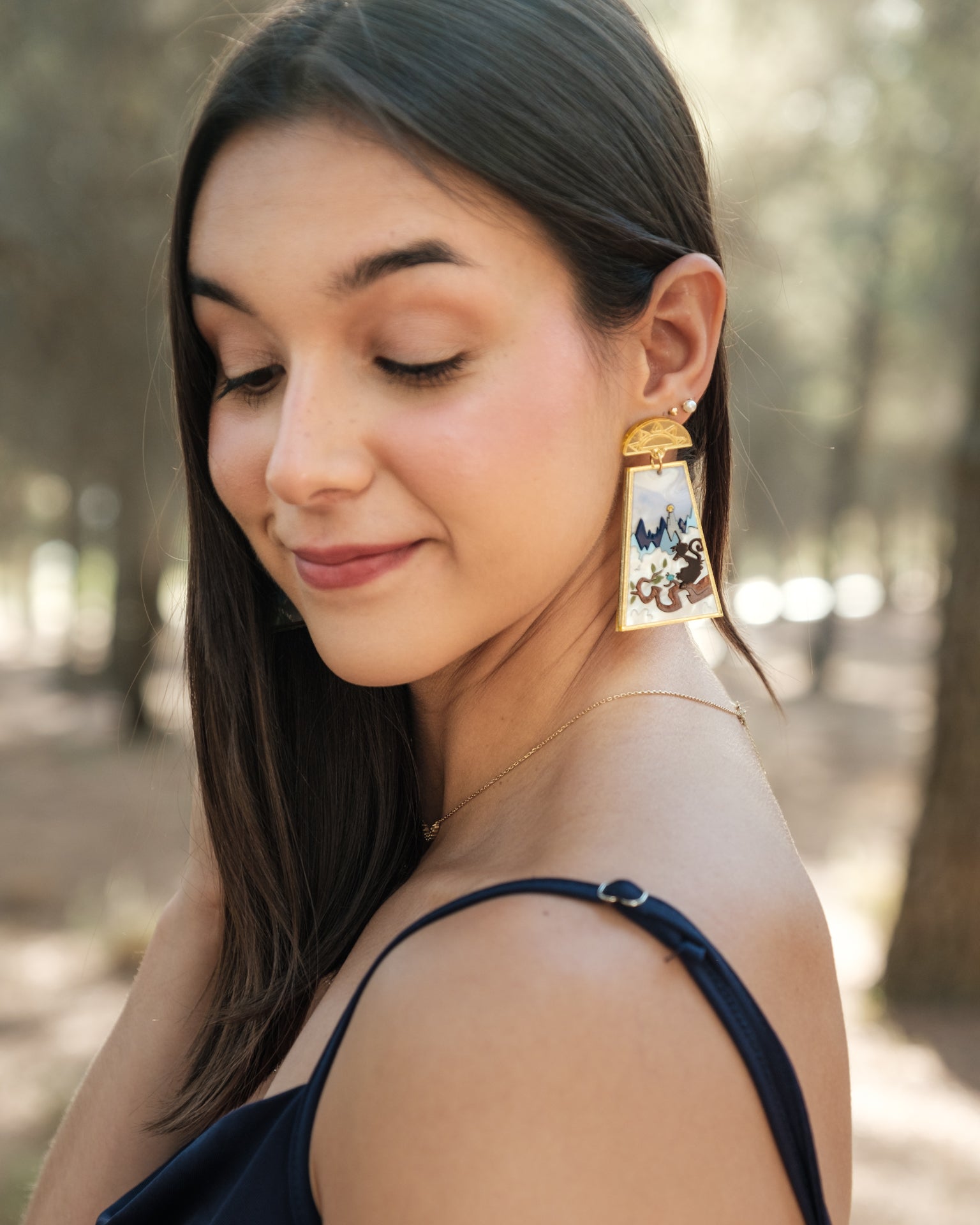 Pendientes edición especial de metacrilato, en tonos azules, blancos y dorados y con diferentes texturas para crear este modelo único. Foto de modelo luciendo el pendiente