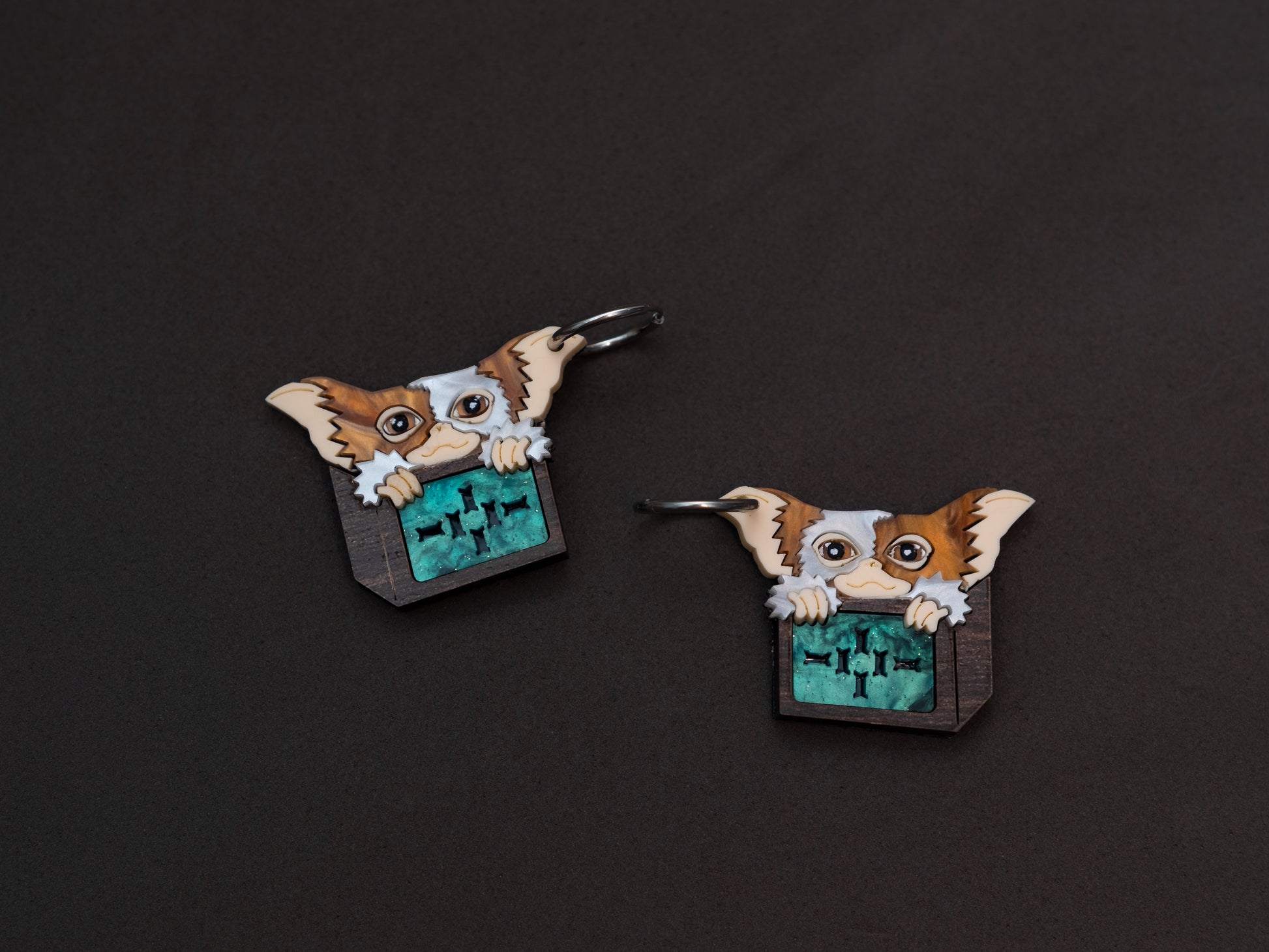 Pendientes de metacrilato inspirados en los gremlins. Gizmo en su cajita de madera todo hecho con metacrilato y plancha de madera. Aros de acero inoxidable