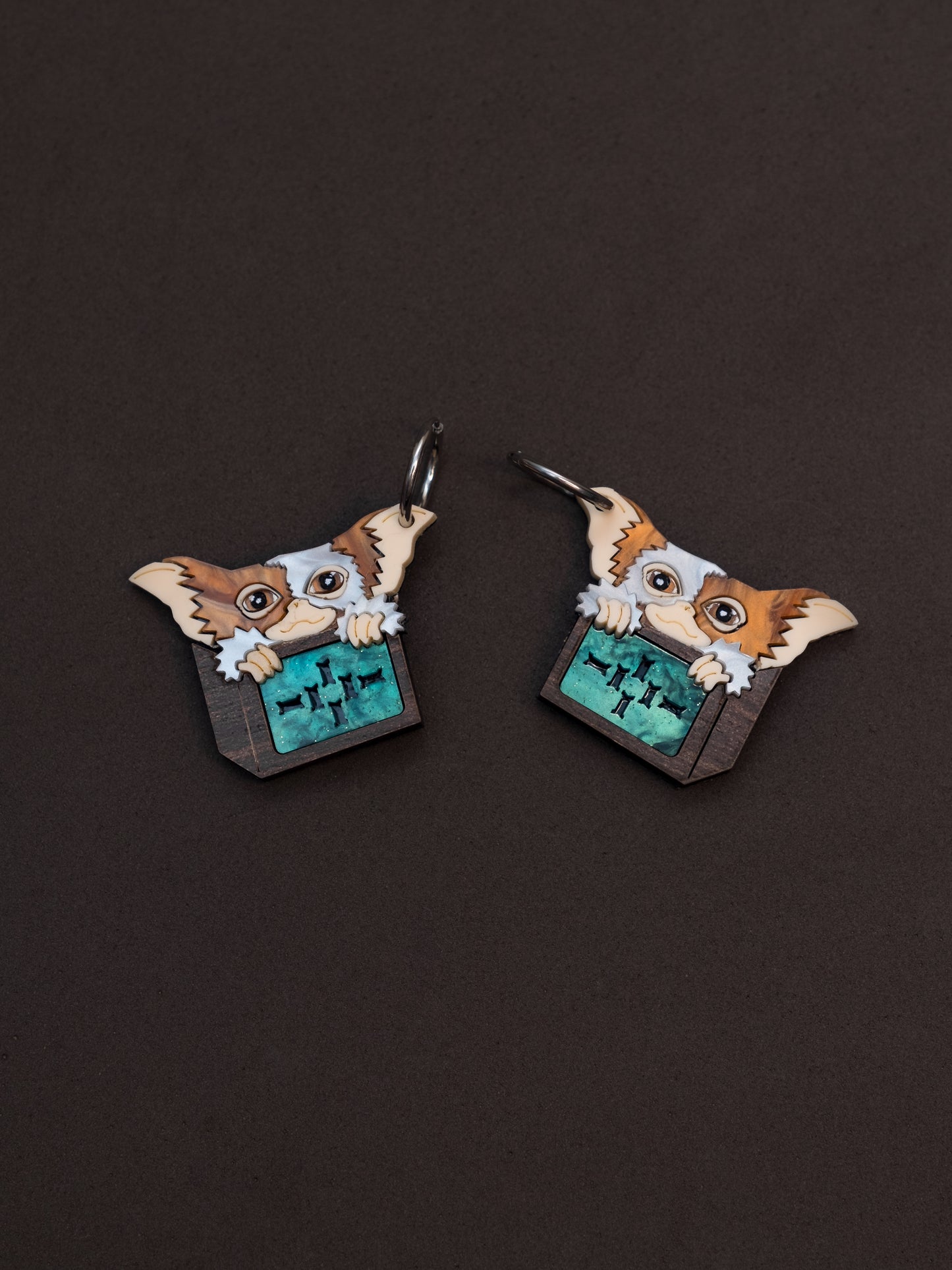 Pendientes de metacrilato inspirados en los gremlins. Gizmo en su cajita de madera todo hecho con metacrilato y plancha de madera. Aros de acero inoxidable