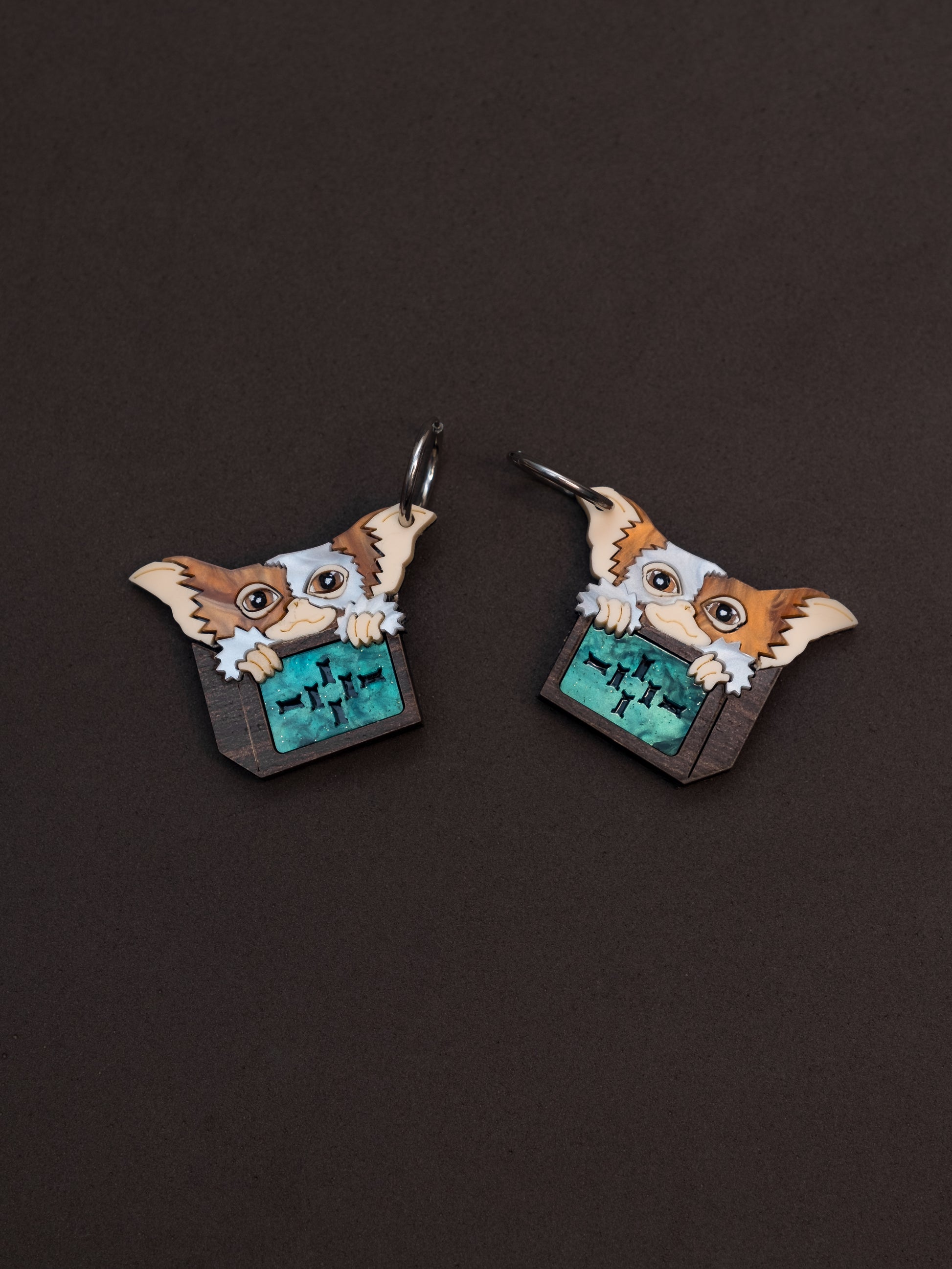 Pendientes de metacrilato inspirados en los gremlins. Gizmo en su cajita de madera todo hecho con metacrilato y plancha de madera. Aros de acero inoxidable