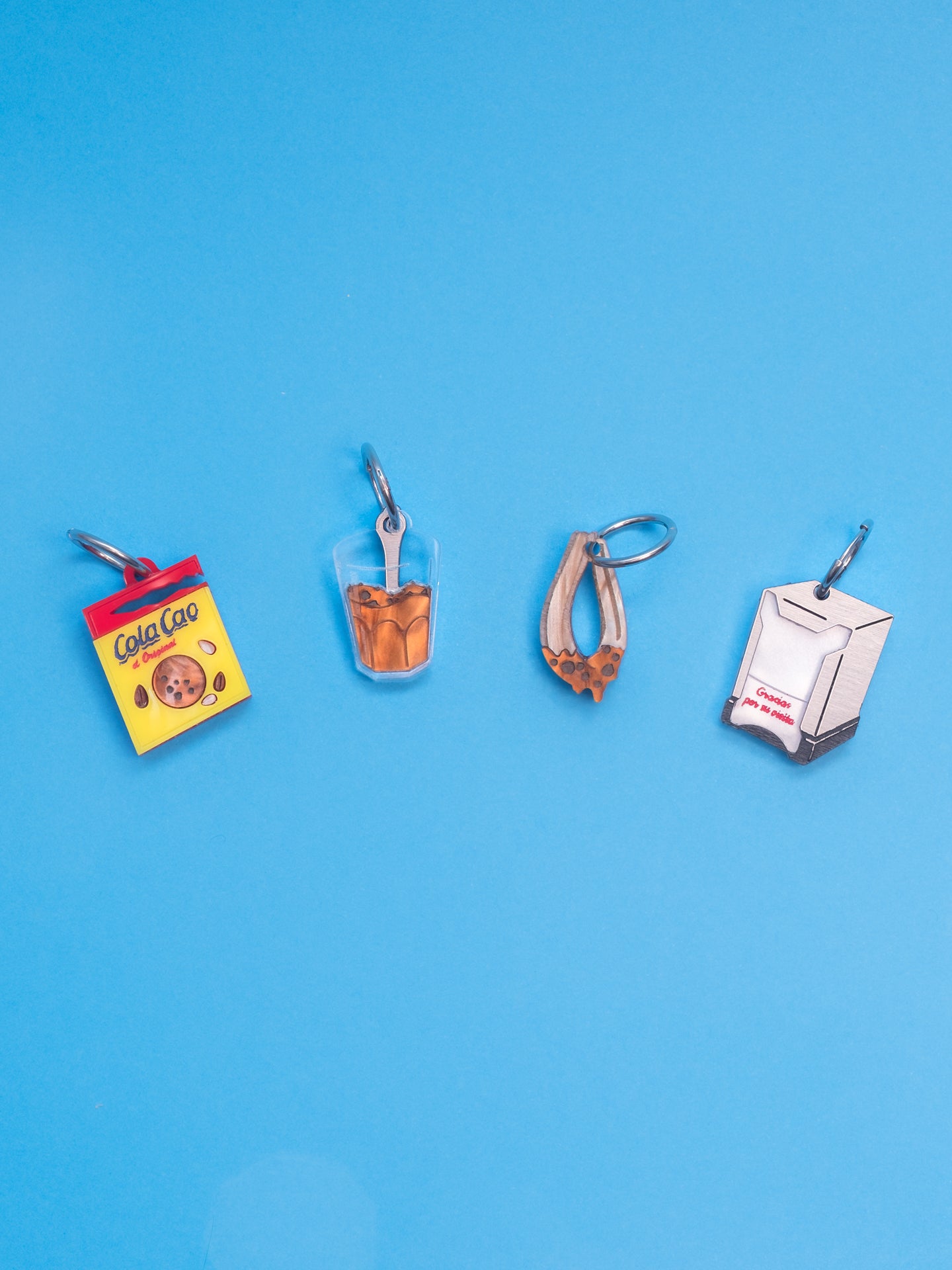 Pendientes de The90sisters x ColaCao, hechos en metacrilato, este pack contiene el Sobre de ColaCao, el vaso con grumitos, el churro mojado en ColaCao y el Servilletero de toda la vida. Producto oficial