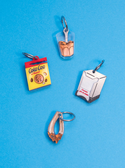 Pendientes de The90sisters x ColaCao, hechos en metacrilato, este pack contiene el Sobre de ColaCao, el vaso con grumitos, el churro mojado en ColaCao y el Servilletero de toda la vida. Producto oficial