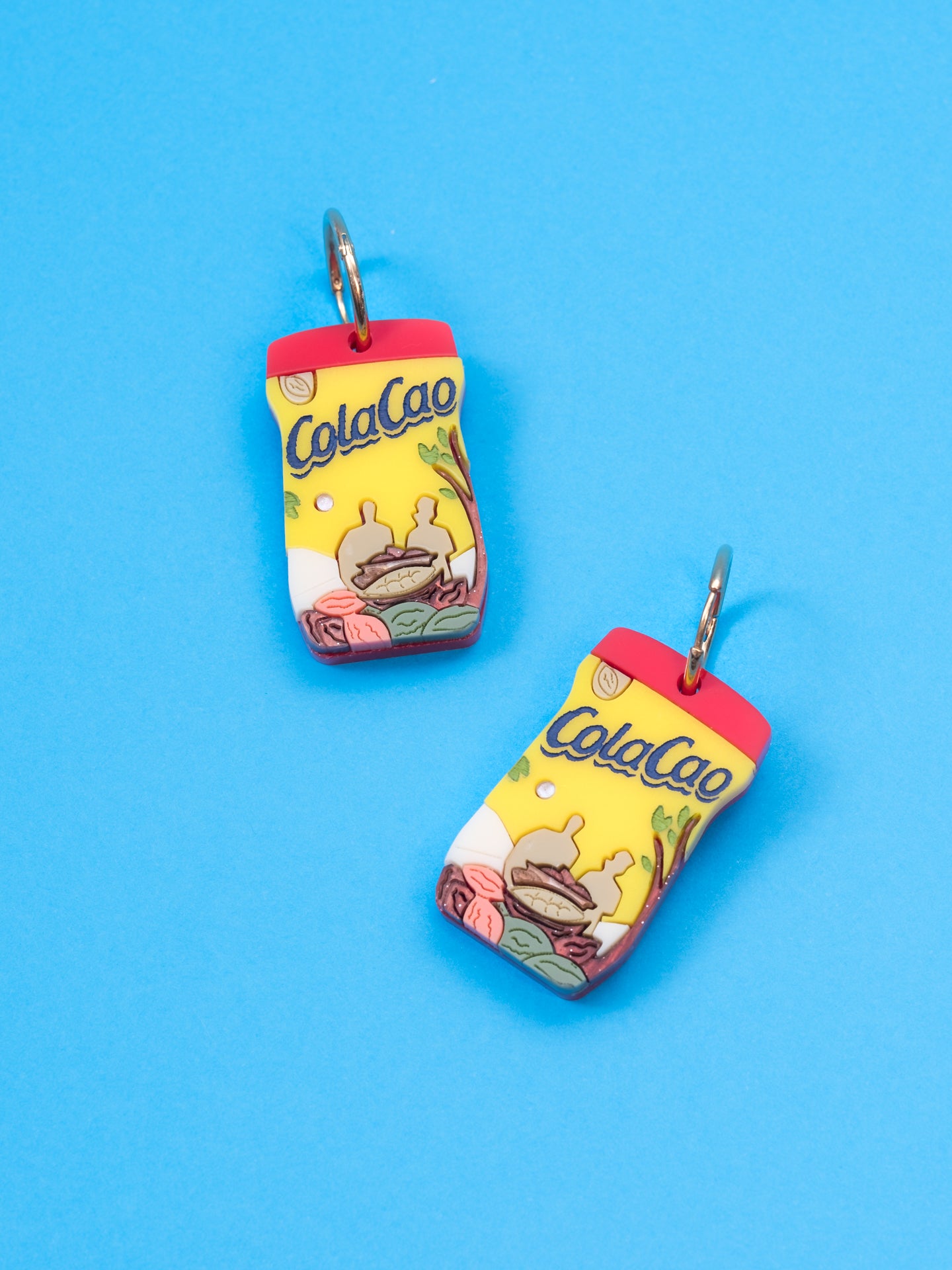 Pendientes de The90sisters x ColaCao, hechos en metacrilato con los colores del bote original de ColaCao, luce estos maxi botes de ColaCao en cualquier ocasión. Producto oficial