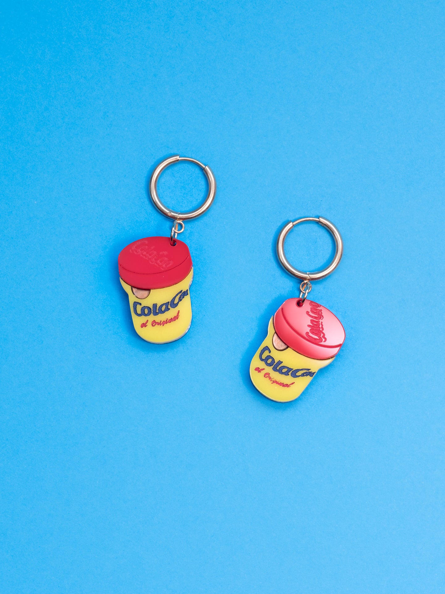 Pendientes de The90sisters x ColaCao, hechos en metacrilato con los colores del bote original de ColaCao, luce estos mini botes de ColaCao en cualquier ocasión. Producto oficial