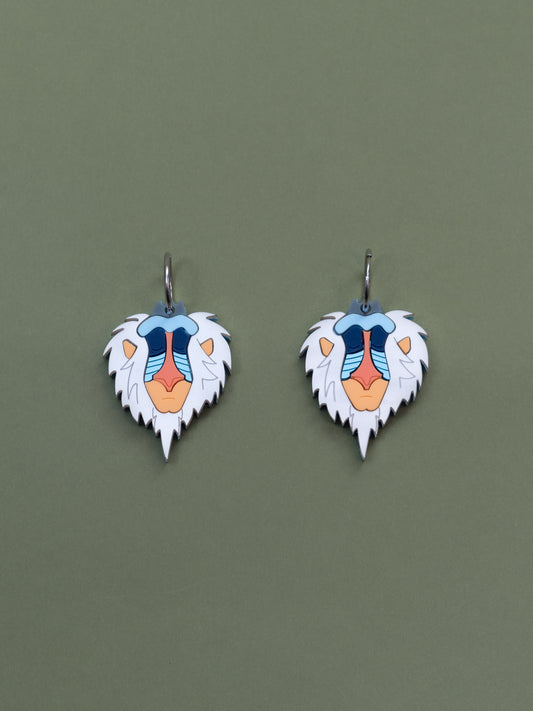 Pendientes inspirados en Rafiki el mandril más querido, en metacrilato blanco aguas naranjas y azules metalicos y brillantes.