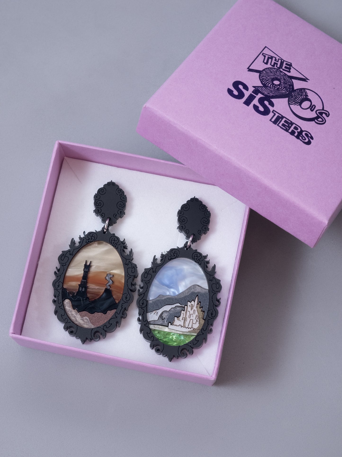 Pendientes de metacrilato inspirado en los paisajes de el señor de los anillos. Hecho a mano por piezas de diferentes colores. Mostrados en su caja.
