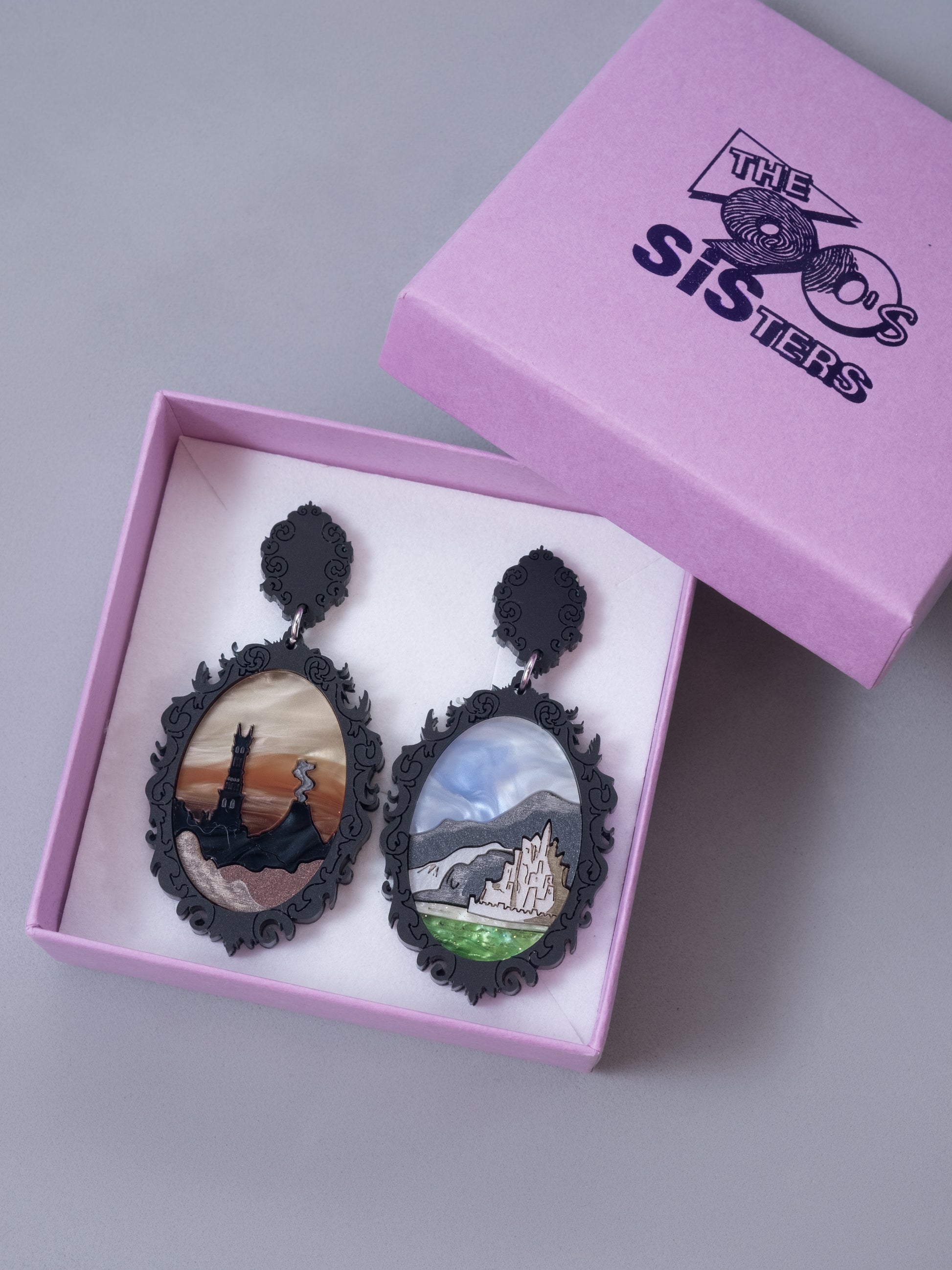 Pendientes de metacrilato inspirado en los paisajes de el señor de los anillos. Hecho a mano por piezas de diferentes colores. Mostrados en su caja.