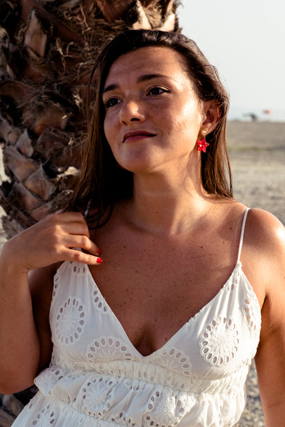 Pendientes de metacrilato rojo claro marmolado en forma de estrellita y con detalles de perlas en blanco y dorado ideales para los paseos de las vacaciones en la playa