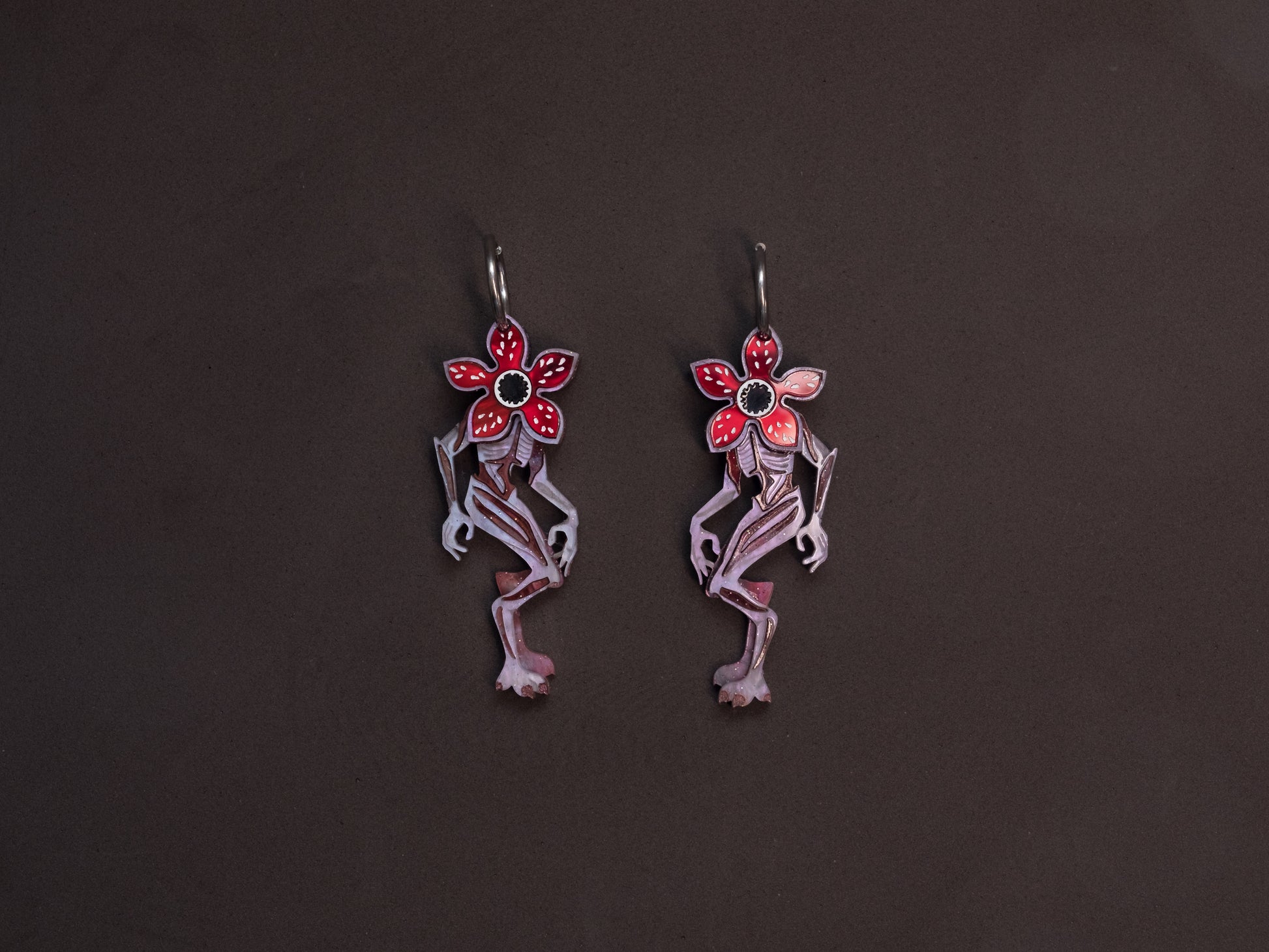 Pendientes de metacrilato inspirados en stranger things, en el demogorgon, con colores marmolados purpura, rojo y marrón que dan un toque espectacular a esta criatura. Con aro de acero inoxidable incluido