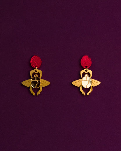 Pendientes inspirados en aladdin, metacrilato dorado metálico y espejo para el escarabajo y rojo espejo para la joya prohibida, unidos con anilla de acero inoxidable dorada para crear estos pendientes de botón