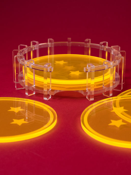Posavasos de metacrilato fluor naranja inspirados en las Bola de dragón, los siete posavasos reunidos en un soporte de metacrilato transparente