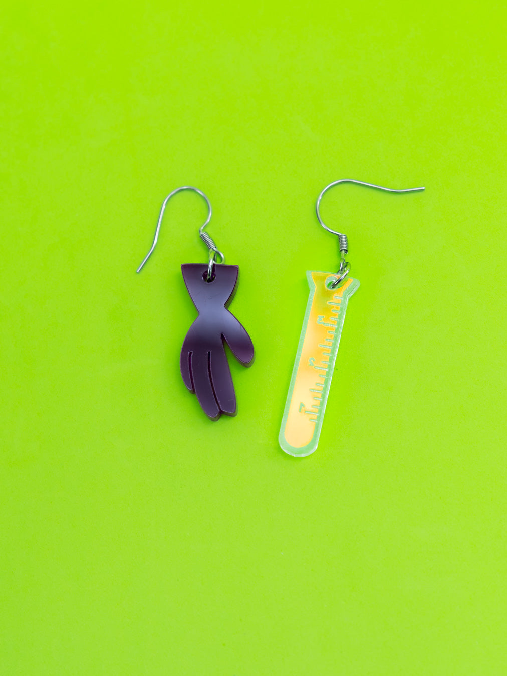 Pendientes de metacrilato con forma de guante y probeta iridiscente. Inspirados en Dexter, del laboratorio de Dexter