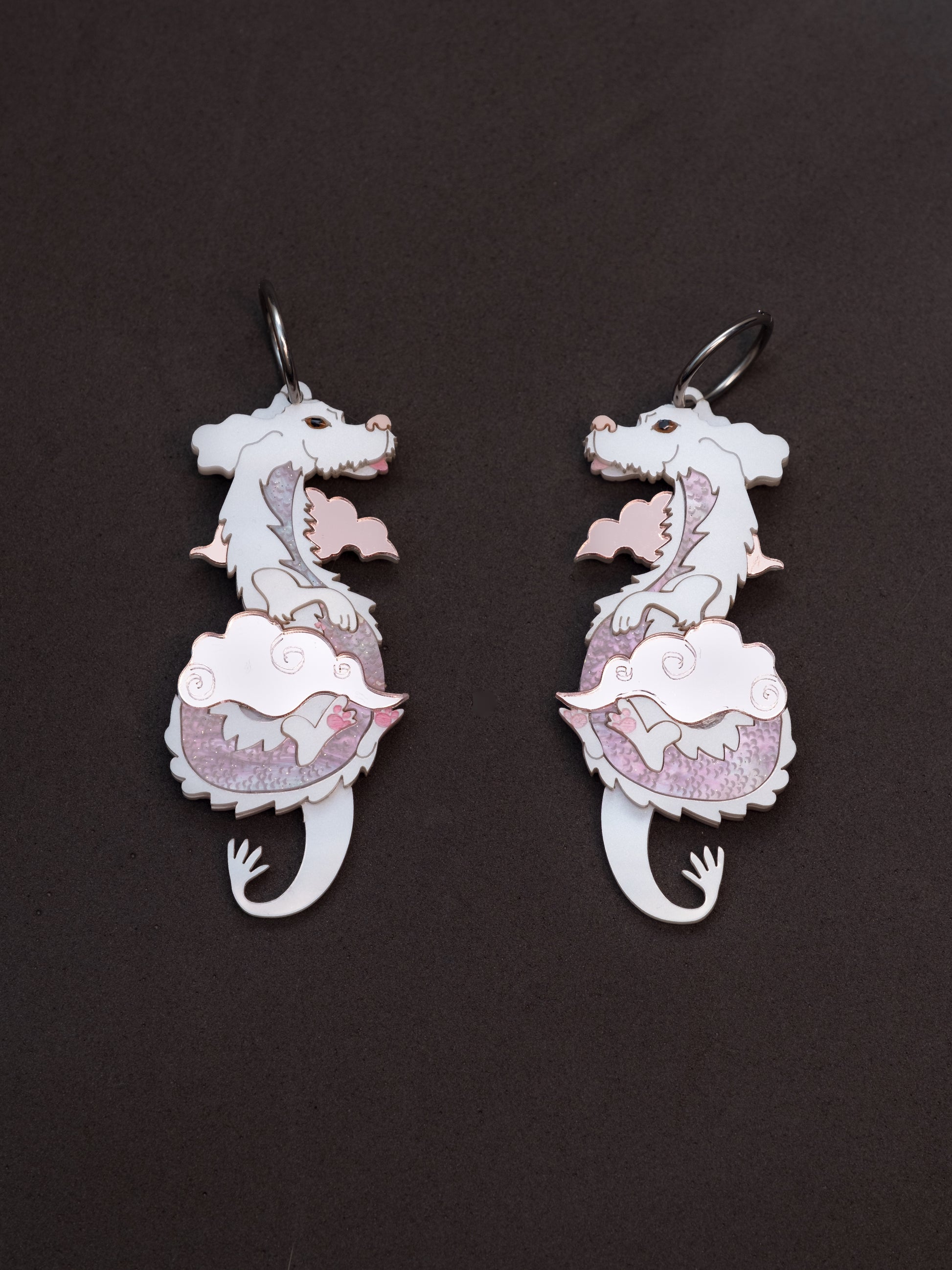 Pendientes de metacrilato inspirados en la historia interminable. El dragon blanco de la suerte con metacrilatos tonos rosa. Toda una joya colgada con aros de acero inoxidable