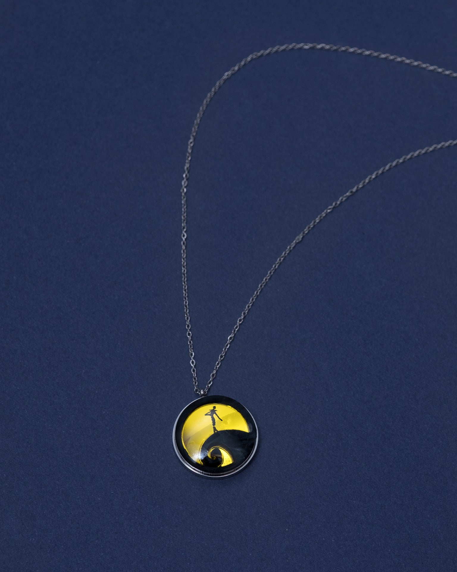 Collar de acero inoxidable con metacrilato y resina inspirado en La clasica pelicula pesadillas antes de navidad, con material dorado espejo y negro aguas