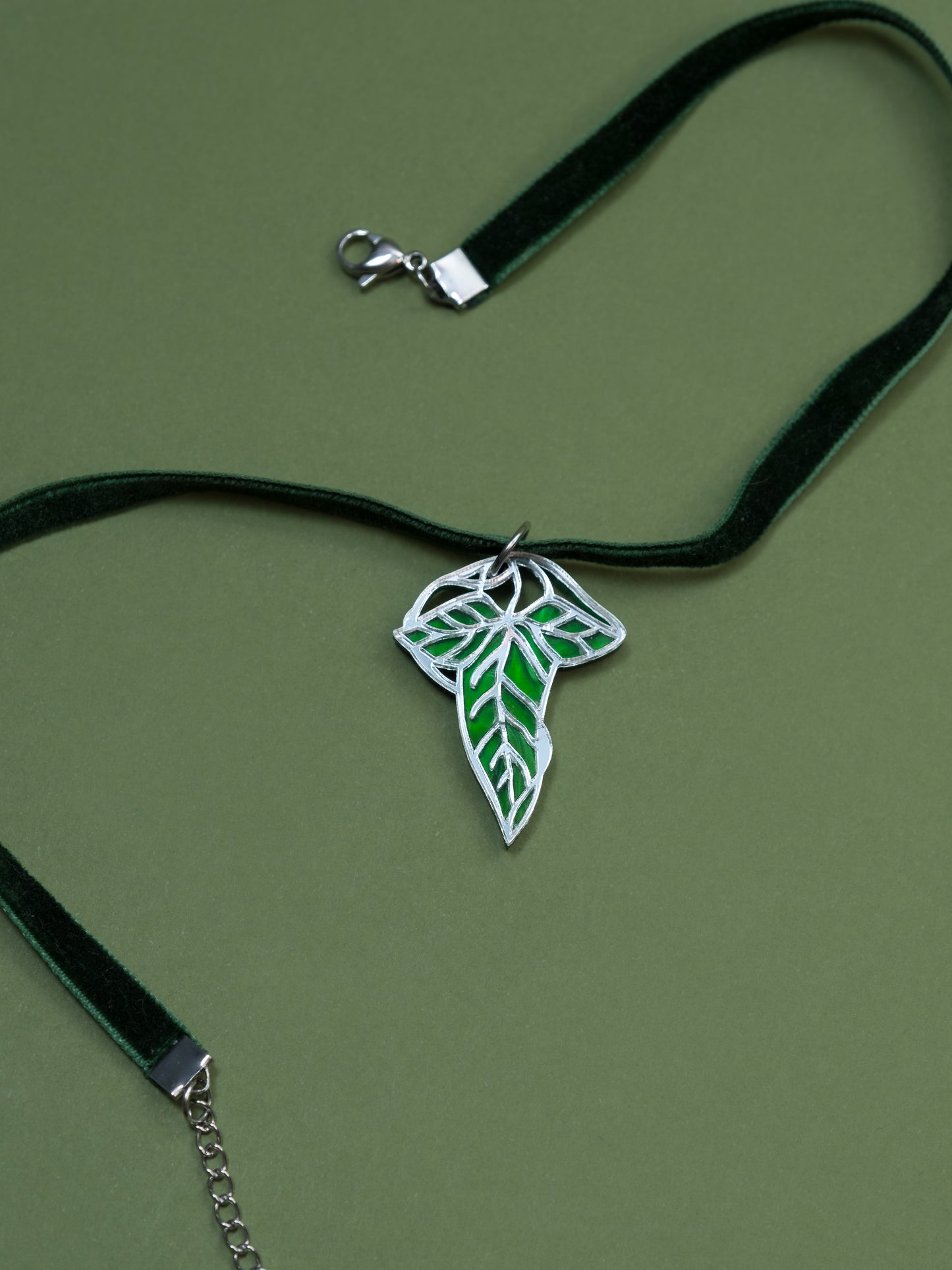 Choker de metacrilato inspirado en el señor de los anillos. La hoja esta hecha con metacrilato verde aguas y espejo plateado. Choker en verde con cierre en plateado 