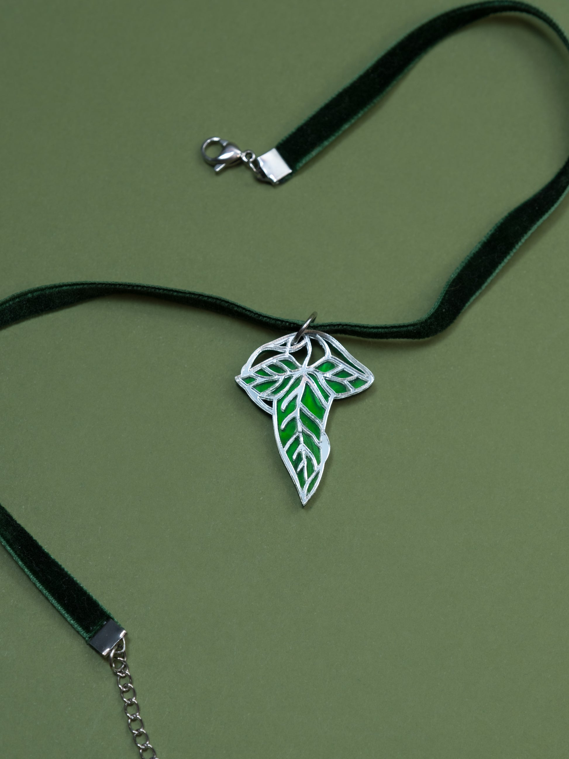 Choker de metacrilato inspirado en el señor de los anillos. La hoja esta hecha con metacrilato verde aguas y espejo plateado. Choker en verde con cierre en plateado 