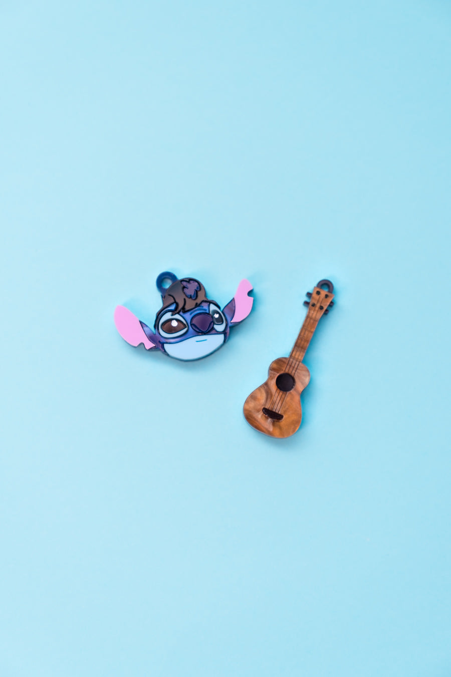 Pendientes de metacrilato inspirados en Stitch disfrazado de Elvis y con su ukelele. Aros en acero inoxidable.