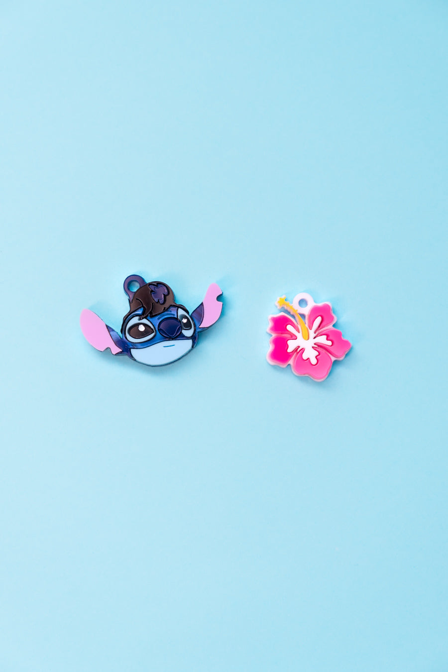 Pendientes de metacrilato inspirados en Stitch disfrazado de Elvis y con una flor de hibisco hawaiana. Aros en acero inoxidable 