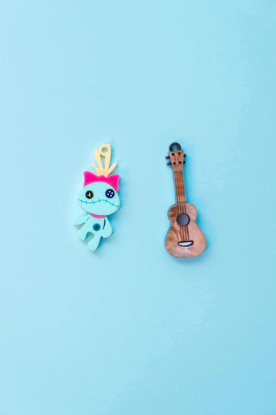 Pendientes de metacrilato inspirados en Scrump la muñeca se Lilo junto al ukelele de Stitch. Aros en acero inoxidable.