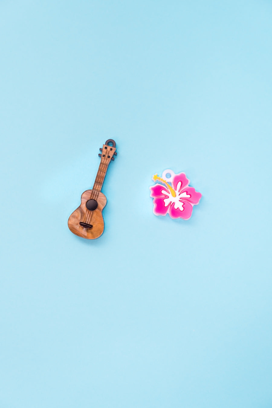 Un ukelele y una flor hawaiana inspirados en la película de Lilo y Stitch. Aros en acero inoxidable.