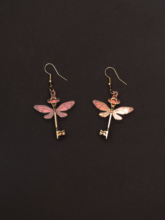 Pendientes de metacrilato inspirados en el mundo mágico. Estas llaves mágicas voladoras llevan metacrilato dorado bicapa y iridiscentes colgadas con ganchitos de acero inoxidable dorado