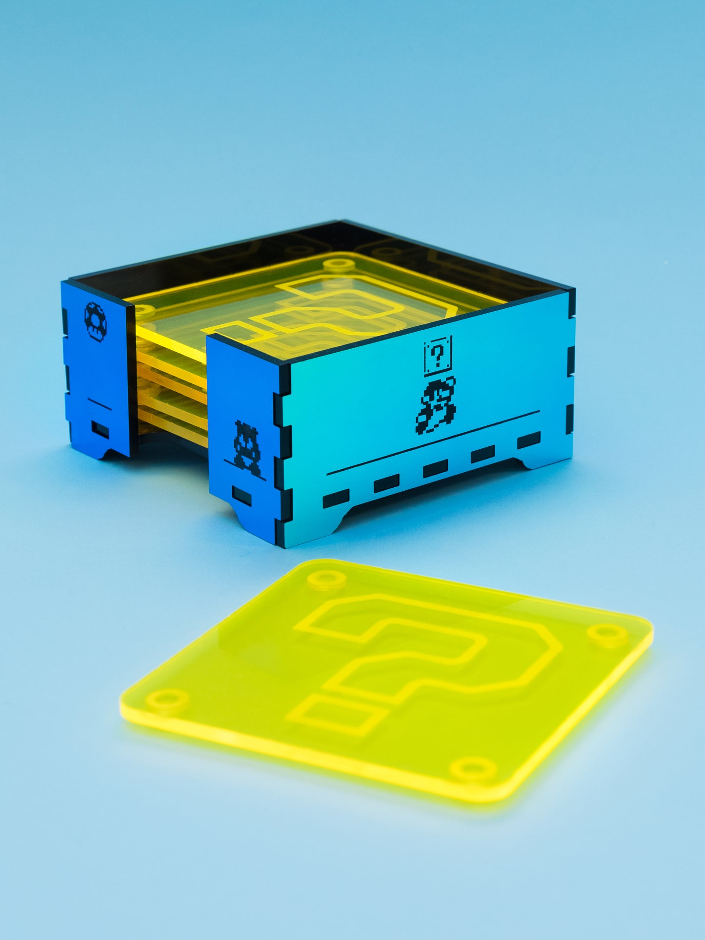 Posavasos de metacrilato inspirados en mario bros, los posavasos son amarillo fluor con su gotas antideslizantes y la caja en metacrilato espejo iridiscente con grabados de escenas de mario