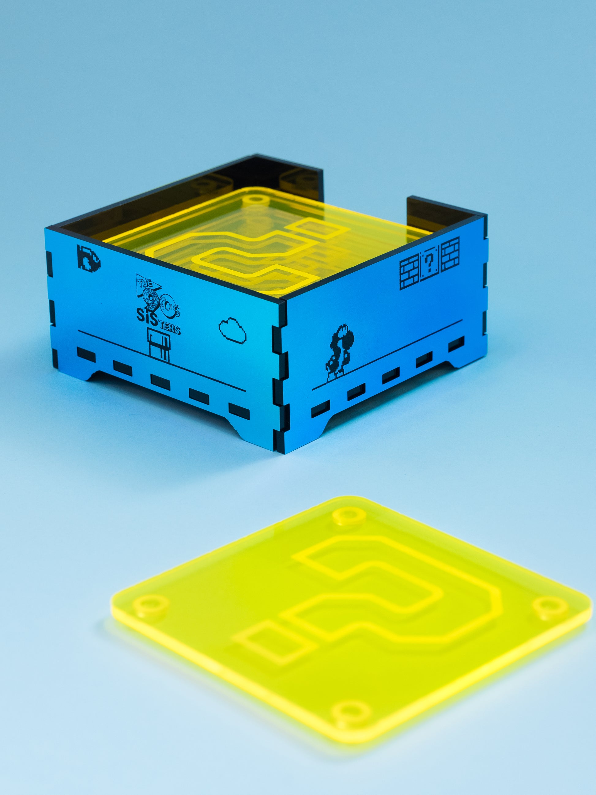 Posavasos de metacrilato inspirados en mario bros, los posavasos son amarillo fluor con su gotas antideslizantes y la caja en metacrilato espejo iridiscente 