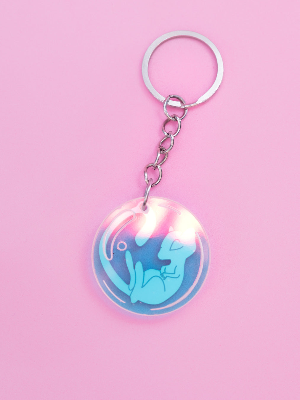 Llavero de metacrilato inspirado en la serie Pokémon, en este caso el nº151 Mew en rosa metalizado y burbuja en iridiscente. Con llavero de acero inoxidable