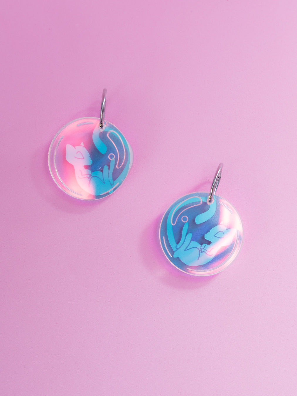Pendientes de metacrilato inspirados en la serie Pokémon, en este caso el nº151 Mew en rosa metalizado y burbuja en iridiscente. Con aros de acero inoxidable
