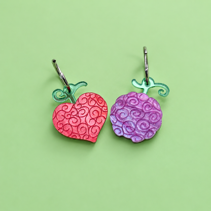 Pendientes inspirados en tu anime favorito, Nueces de belcebu o frutas del diablo hechas de metacrilato de diferentes colores, en este caso pareja de pendientes una en rojo aguas y otra en morado aguas. Ope ope no mi y gomu gomu no mi