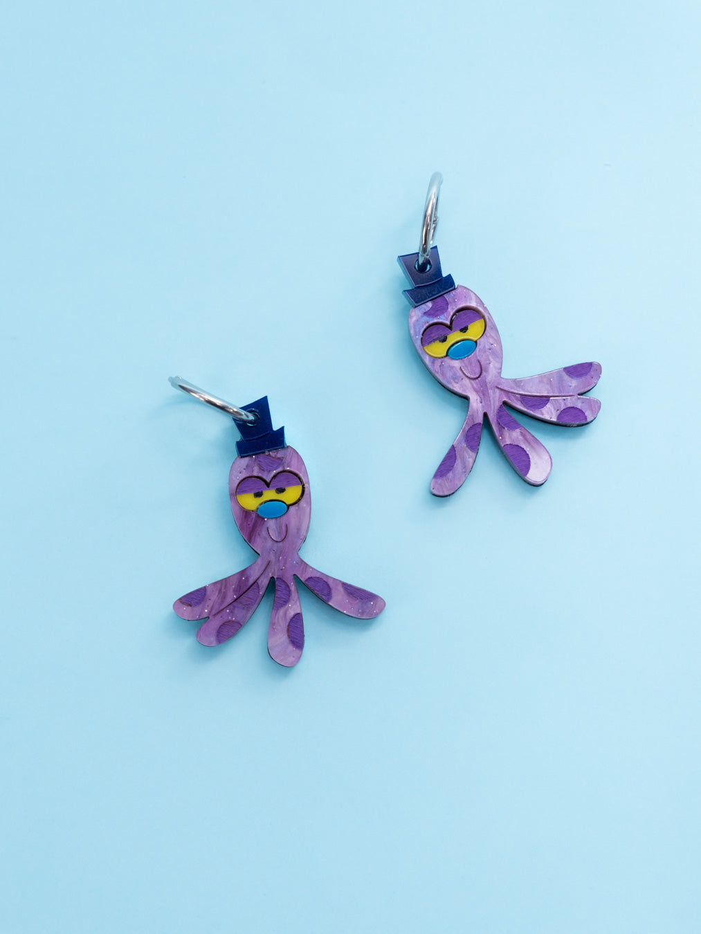 Pendientes de metacrilato inspirados en Octi el peluche de Burbuja de las Supernenas. Con efecto morado aguas.
