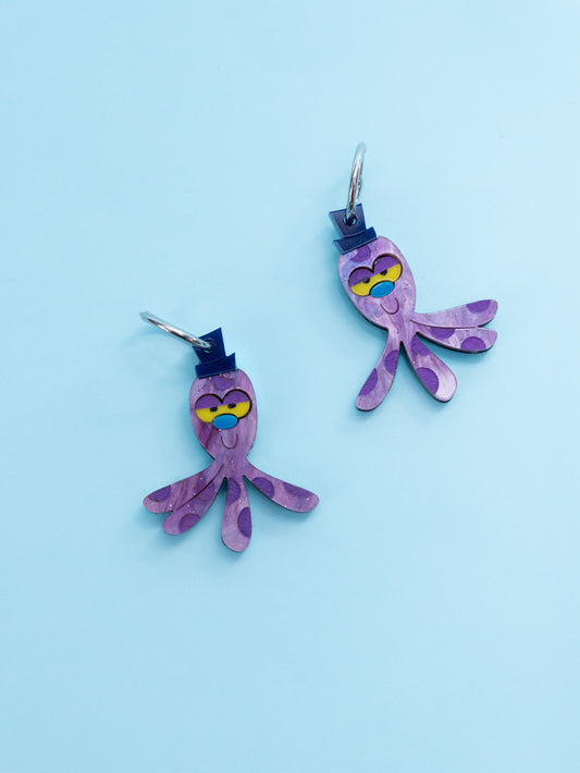 Pendientes de metacrilato inspirados en Octi el peluche de Burbuja de las Supernenas. Con efecto morado aguas.