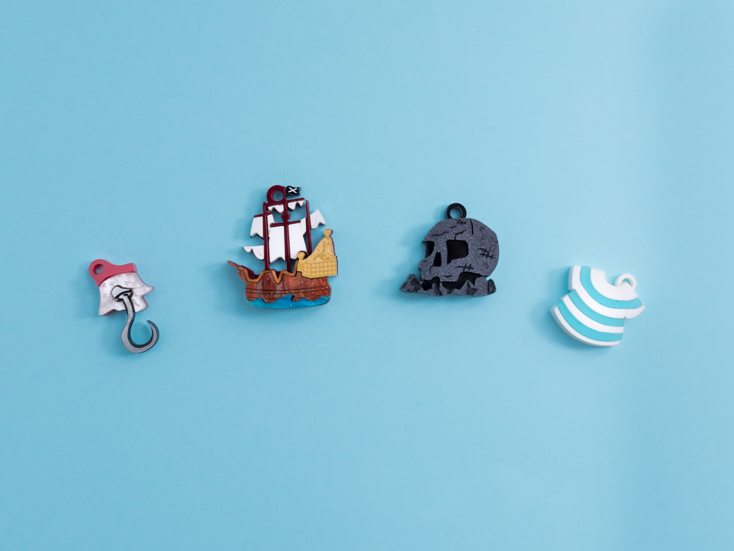 Pack de pendientes de metacrilato inspirados en peter pan, aprecen la isla calavera, el garfio, el barco y la camiseta de Smith, todos en colores con efectos marmolados, metálicos o piedra según el modelo