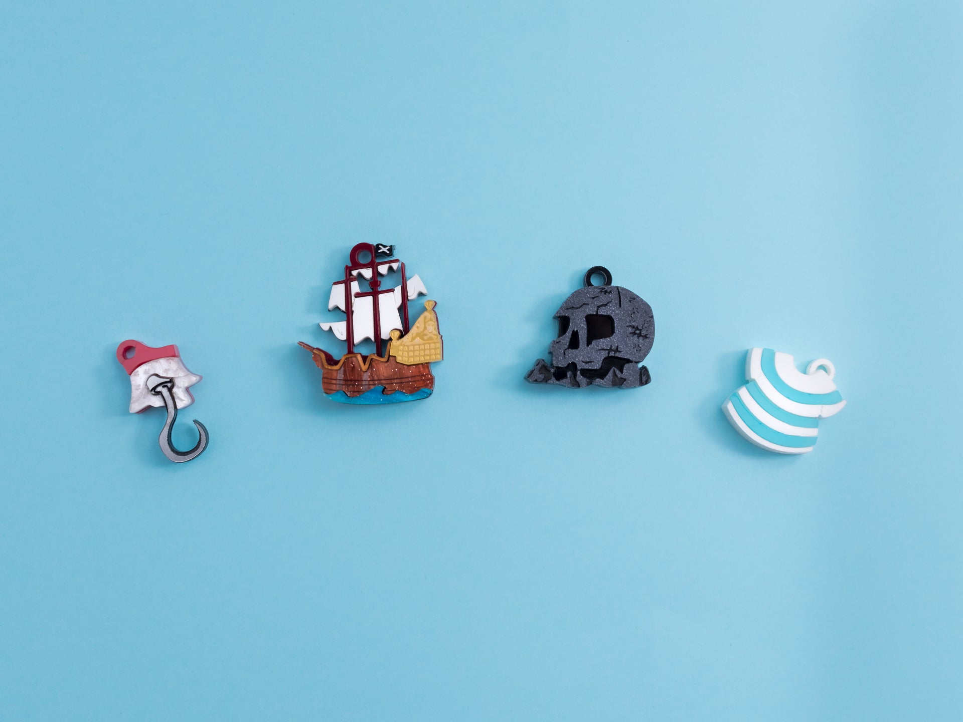 Pack de pendientes de metacrilato inspirados en peter pan, aprecen la isla calavera, el garfio, el barco y la camiseta de Smith, todos en colores con efectos marmolados, metálicos o piedra según el modelo