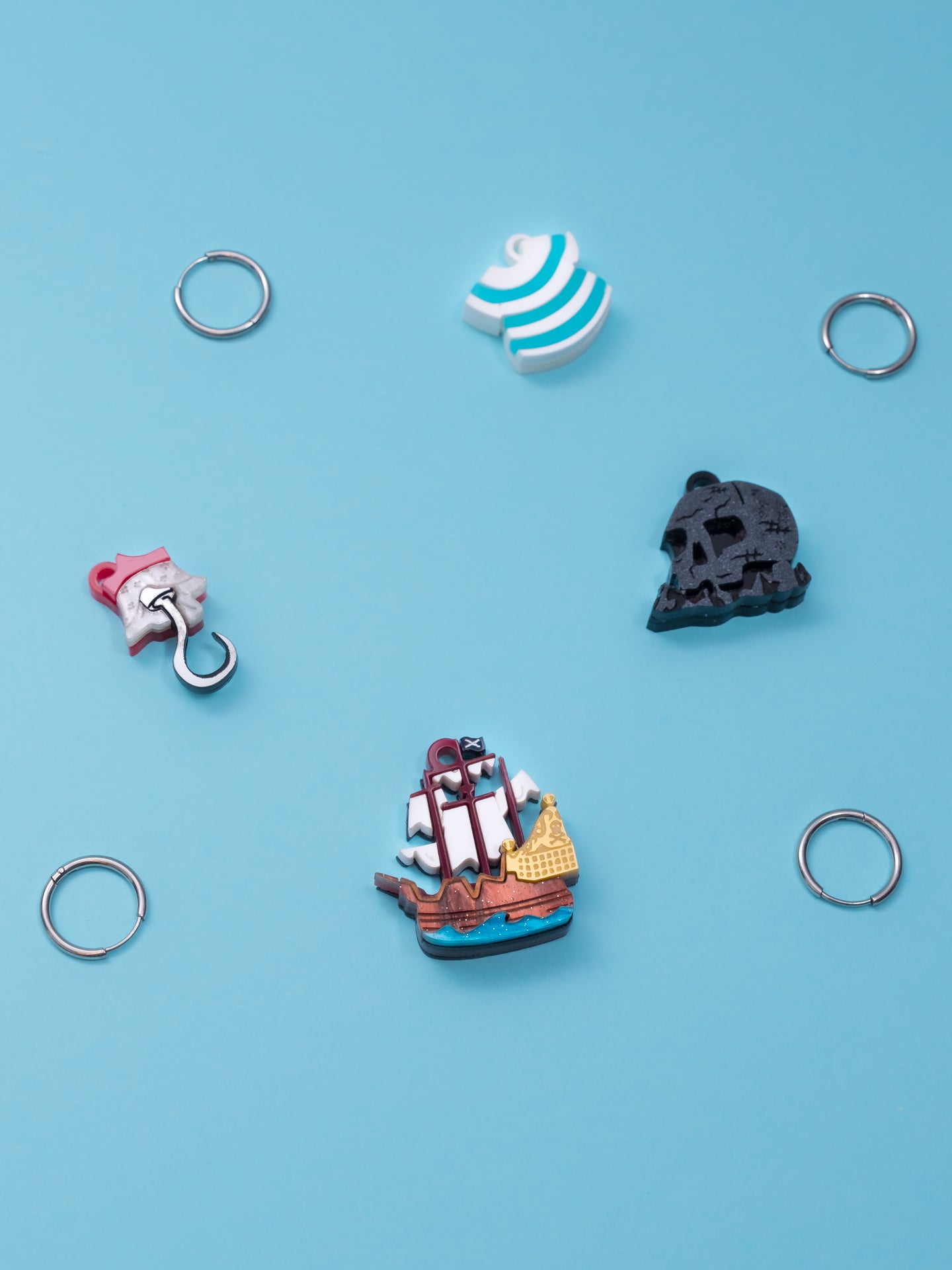 Pack de pendientes de metacrilato inspirados en peter pan, aprecen la isla calavera, el garfio, el barco y la camiseta de Smith, todos en colores con efectos marmolados, metálicos o piedra según el modelo