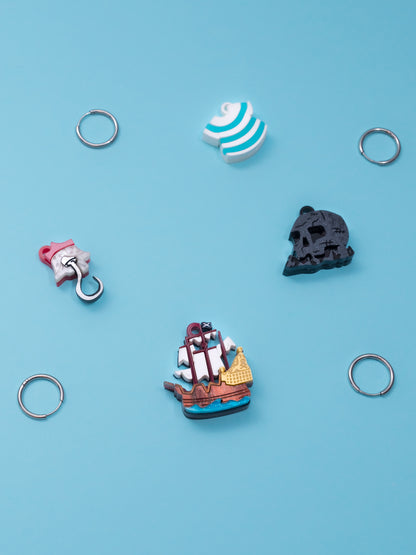 Pack de pendientes de metacrilato inspirados en peter pan, aprecen la isla calavera, el garfio, el barco y la camiseta de Smith, todos en colores con efectos marmolados, metálicos o piedra según el modelo