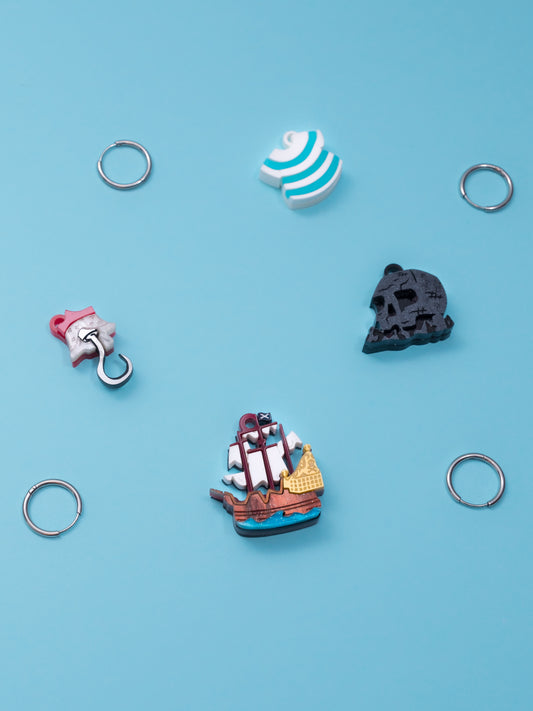 Pack de pendientes de metacrilato inspirados en peter pan, aprecen la isla calavera, el garfio, el barco y la camiseta de Smith, todos en colores con efectos marmolados, metálicos o piedra según el modelo