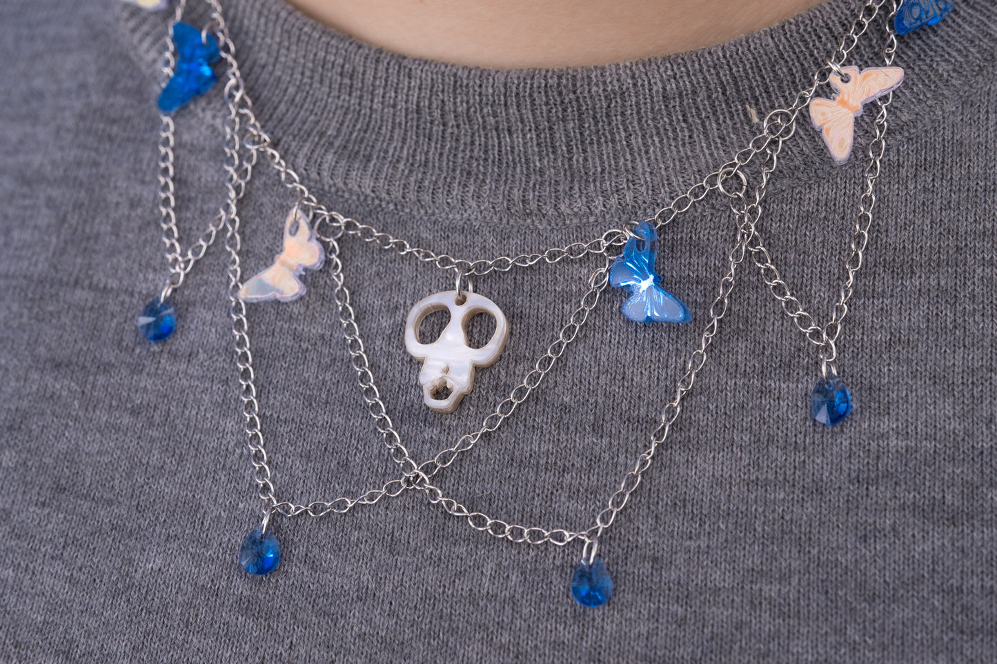 Collar de metacrilato y acero inox. inspirado en las películas de Tim Burton, mariposas espejo, azul e iridiscente culminadas con cristales gota azul y la cabeza de Scraps en el centro para dar ese aspecto elegante y spooky