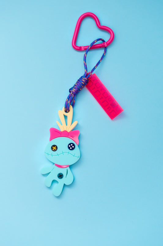 Maxillavero de Scrump la muñeca de Lilo en colores pastel mate. Anilla con forma de corazón y cartelito neón.